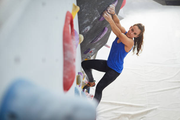 istock Indoor climbing, woman climbing on a boulder wall. 1130286179