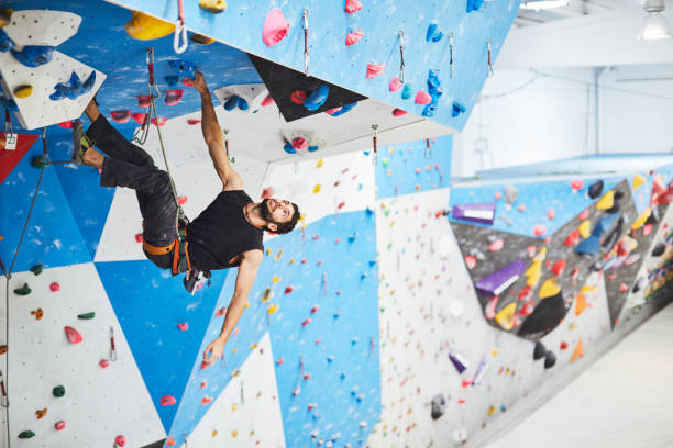 istock Indoor climbing, Man climbing indoor boulder wall. 1130286202