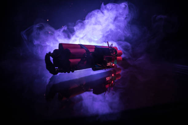 istock Image of a time bomb against dark background. Timer counting down to detonation illuminated in a shaft light shining through the darkness, 1130287044