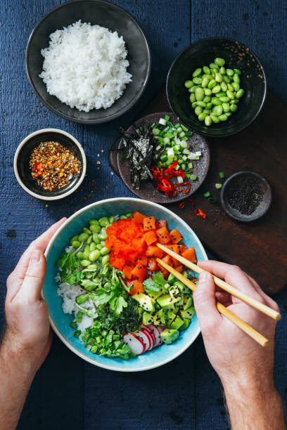 istock Man eating Salmon poke bowl 1130290663