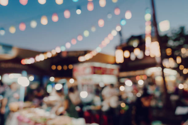 unscharfen hintergrund bei nacht markt festival menschen zu fuß unterwegs. - marktstand stock-fotos und bilder