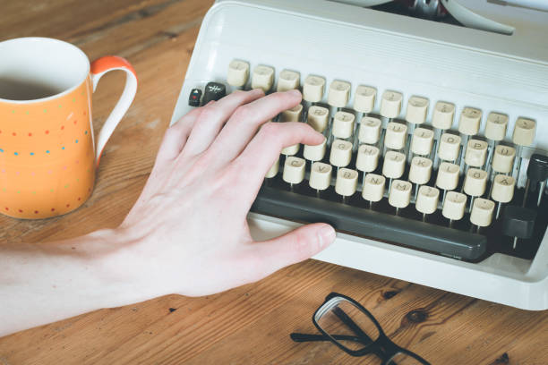 istock Old fashioned vintage typewriter on wooden desk, glasses 1130291316