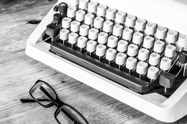 istock Old fashioned vintage typewriter on wooden desk, glasses 1130291934