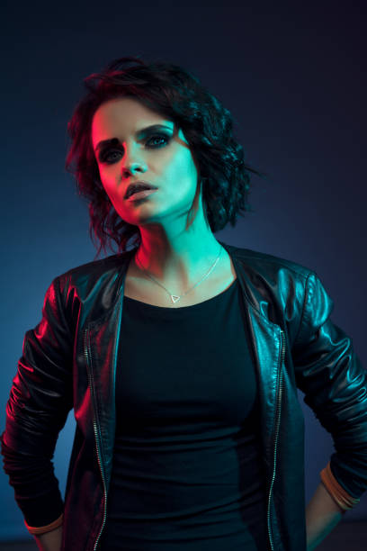 istock Girl in leather jacket studio portrait, neon light 1130292058