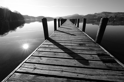 wooden jetty on mirror calm lake