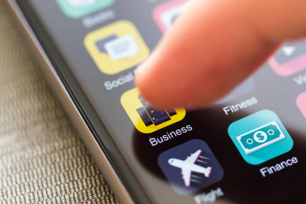 Smart phone home screen with business network icon on focus. Finger tip is about to launch mobile application.