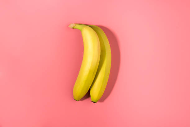 istock Two bananas isolated on a pink background with contrast shadow 1130297802