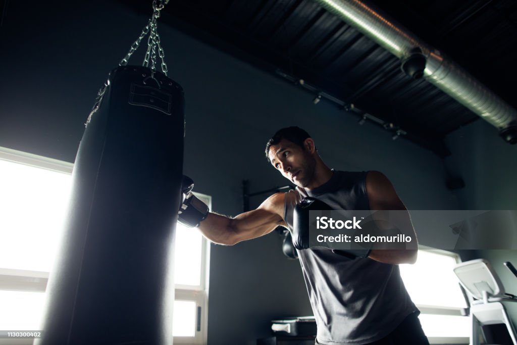 Concentrated young man box training in the gym Concentrated young man box training by himself in the gym. Boxing - Sport Stock Photo