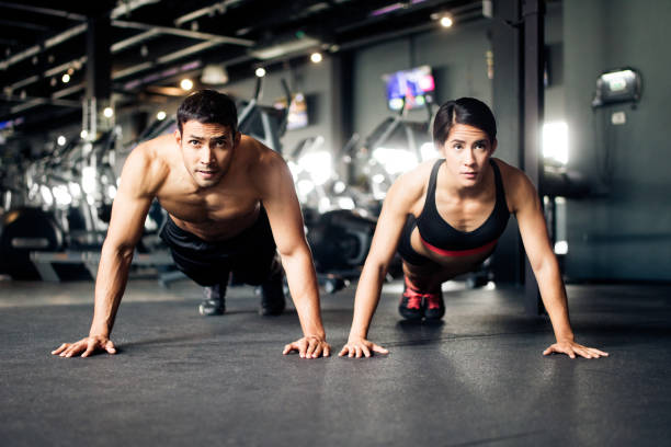 istock Young couple doing pushups in the gym 1130300474