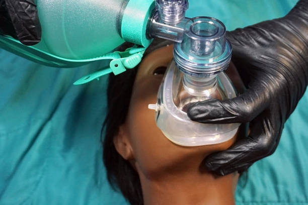 istock Medical stuff in black gloves performing Artificial ventilation using bag valve mask (Ambu bag) on a simulation mannequin dummy during medical training to control of the airway. General Anesthesia. 1130301975