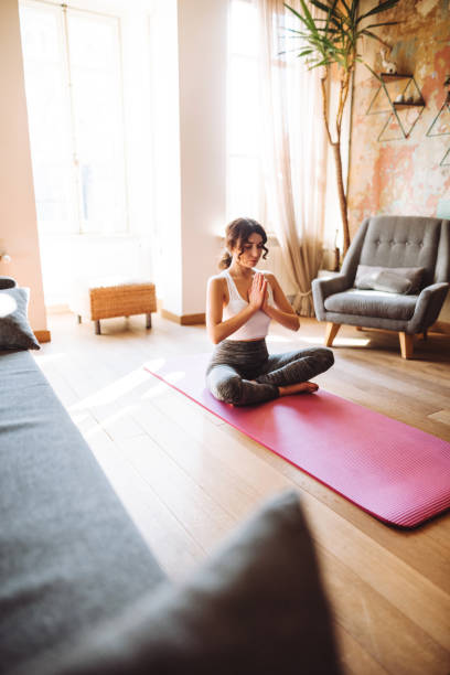 istock woman doing yoga at home 1130302946