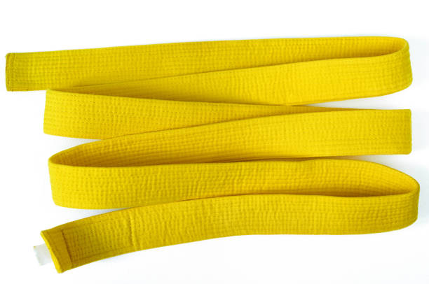 Yellow belt on a white background Clothes for martial arts - karate, aikido, judo. Yellow belt on a white background. yellow belt stock pictures, royalty-free photos & images