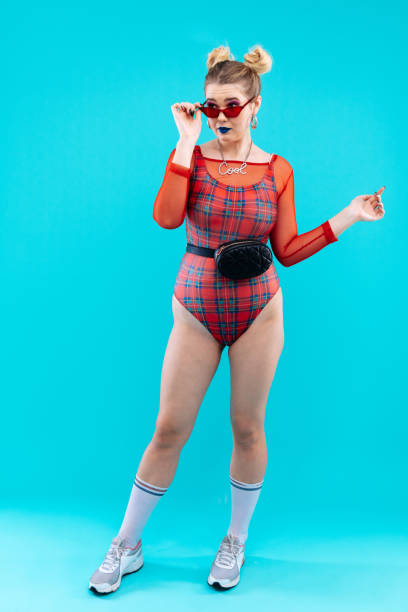 istock Slim model wearing red bodysuit and black waist bag posing 1130303373