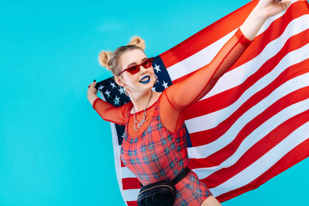 istock Young patriotic woman with bright blue lips holding flag 1130303379