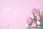Spring tulip flowers on pastel pink background top view. Greeting card for International Women Day or Mother day.