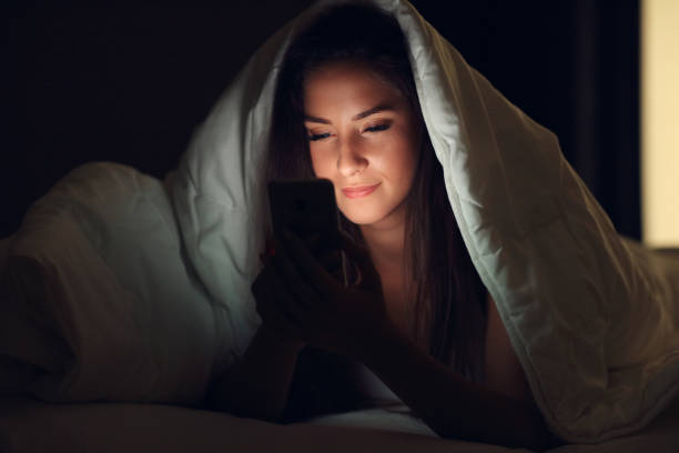 istock Young beautiful woman resting in bed with smartphone 1130307432