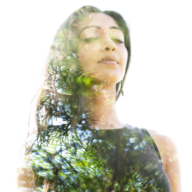 Double exposure close up of a young natural beauty with closed eyes combined with a healthy tree whose branches blend seamlessly into her healthy being Bright and sunny landscape combines with her healthy look think green stock pictures, royalty-free photos & images