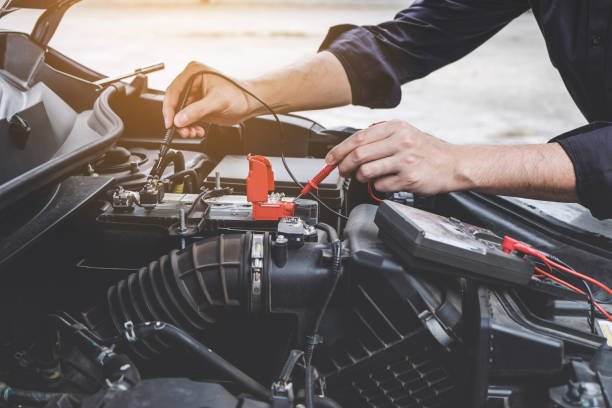 services de conception de l’appareil moteur voiture, mains de mécanicien réparateur automobile vérifiant un atelier automobile de moteur de voiture avec la batterie de test multimètre numérique automobile et l’entretien - digital voltmeter photos et images de collection