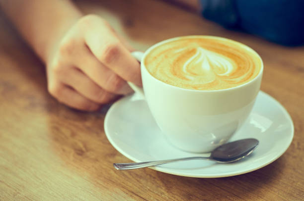 istock Closeup hand with a cup of cappuccino coffee. 1130307996