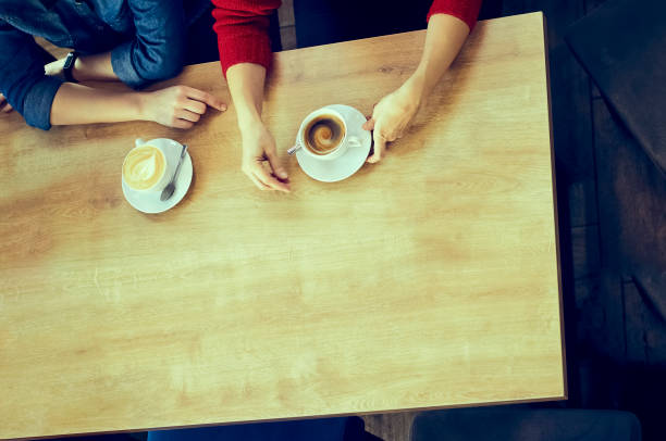 Hands of girlfriends with cups of coffee. Color toning in retro style. Lifestyle women. Love and friendship between people. Free space for text.