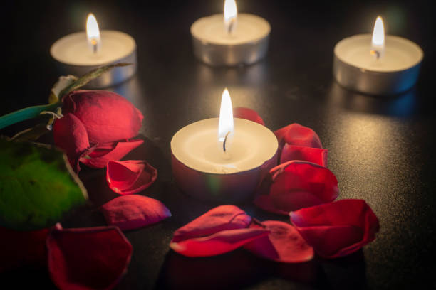 istock Four tea candles and rose petals in the dark 1130308890
