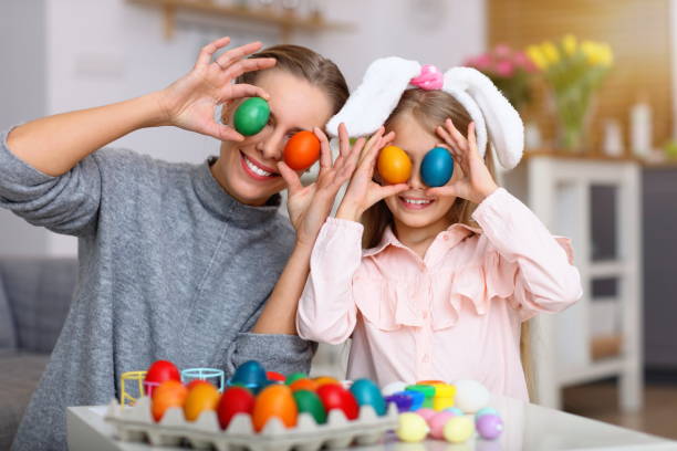 istock Mother and daughter painting Easter eggs 1130309192