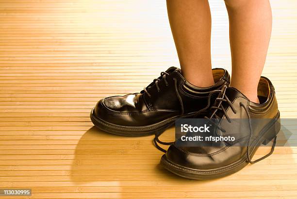 Foto de Grandes Calçados No Currículo Criança Pés Em Grandes Sapato Preto e mais fotos de stock de Sapato