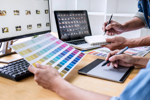istock Two colleagues creative graphic designer working on color selection and drawing on graphics tablet at workplace, Color swatch samples chart for selection coloring 1130310300