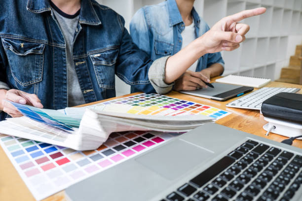 istock Young creative team having a meeting in creative office, Architectural drawing with work tools and accessories, Color swatch samples chart for selection coloring 1130310303
