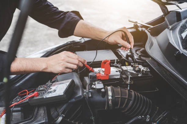 istock Services car engine machine concept, Automobile mechanic repairman hands checking a car engine automotive workshop with digital multimeter testing battery, car service and maintenance 1130310323