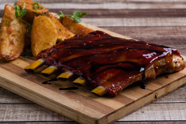grilled pork ribs with potato on wooden table - 7298 imagens e fotografias de stock