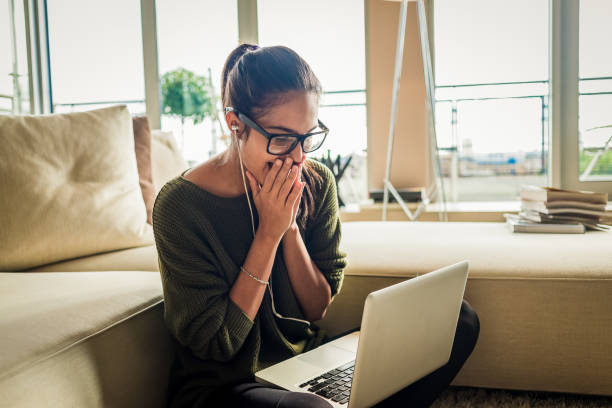 istock cheerful young woman using laptop at home 1130311809