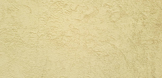 istock Golden yellow concrete wall background with rough swirly texture pattern 1130313660