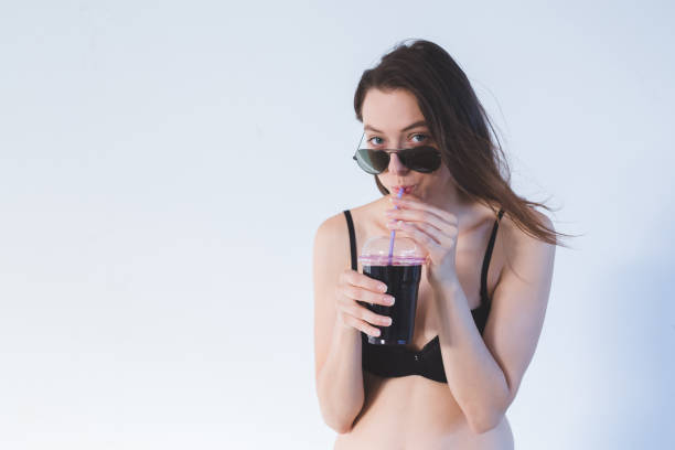 istock Brunette in lingerie drinking juice 1130313968