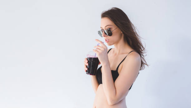 istock Brunette in lingerie drinking juice 1130314094