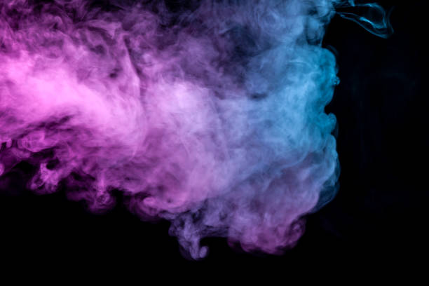 istock Translucent, thick smoke, illuminated by light against a dark background, divided into three colors: blue, green, pink and purple, burns out, evaporating from a steam of vape for print on t-shirt 1130315364