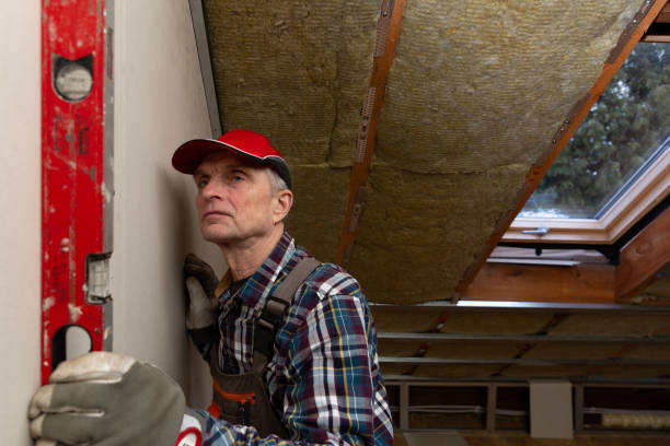 istock Man holding level against interior drywall. Attic insulation and renovation 1130317025