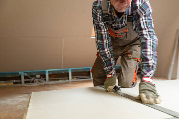 istock Worker cutting drywall plasterboard with construction knife. Attic renovation 1130317336