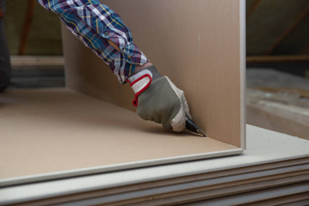 istock Worker cutting drywall plasterboard with construction knife. Attic renovation 1130317839