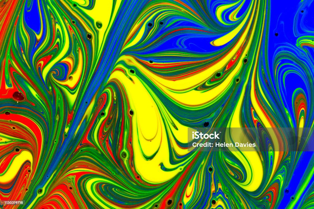 Abstract background of red, yellow green and blue liquid paint swirls Extreme close up of red, yellow, green and blue paint mixing and swirling Abstract Stock Photo