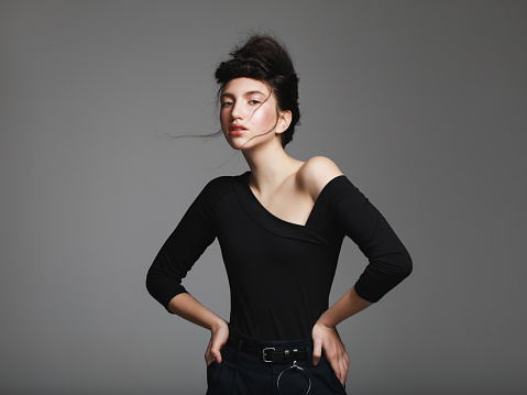 Portrait of millennial girl with retro hairstyle and wearing black top