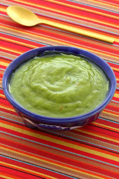 Mexican guacamole, prepared with fresh avocados, lemon juice, vinegar and hot and sweet peppers, on artisan  talavera pottery bowl