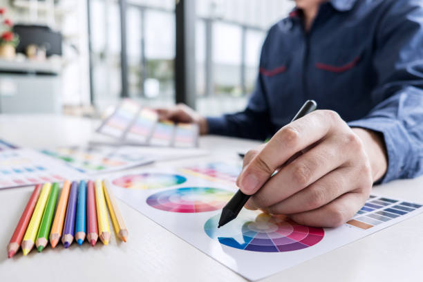 istock Image of male creative graphic designer working on color selection and drawing on graphics tablet at workplace with work tools and accessories 1130323378
