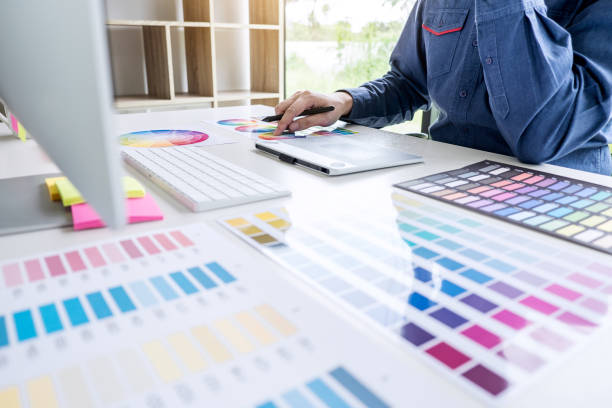 istock Image of male creative graphic designer working on color selection and drawing on graphics tablet at workplace with work tools and accessories 1130323380