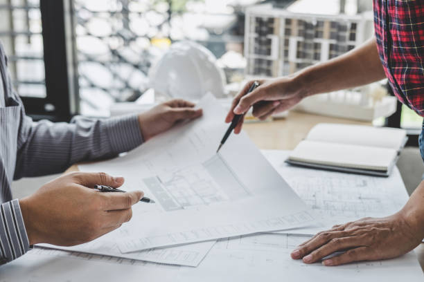 istock Hands of architect or engineer working on blueprint meeting for project working with partner on model building and engineering tools in working site, Construction and structure concept 1130323389