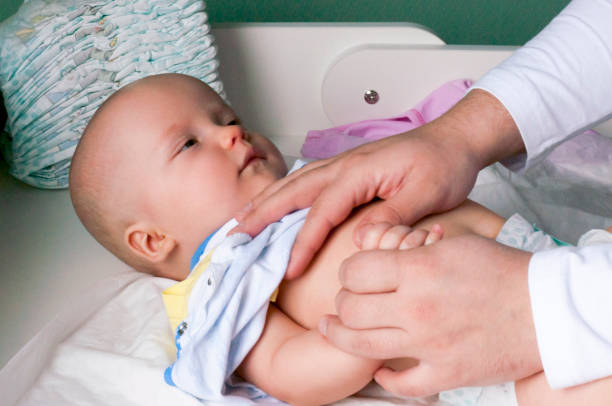 istock Young dad changes the diaper and clothes to his newborn small child. Selective focus. 1130324171