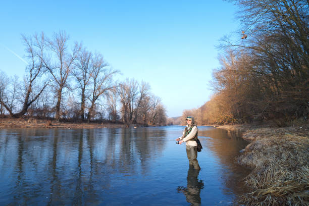 istock Woman catches spinning fish standing in a river 1130328860