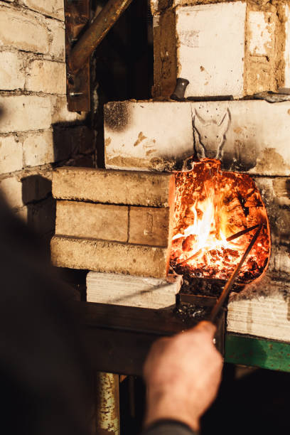 istock a blacksmith kindles a fire in the furnace. 1130330665