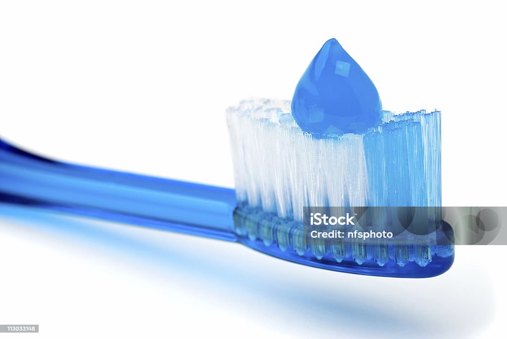 Blue toothpaste on blue toothbrush Closeup of blue toothpaste on blue toothbrush, on white background Blue Stock Photo