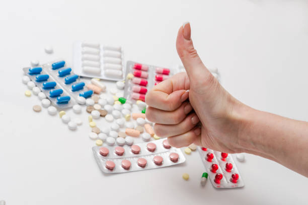 istock Female showing thumb up for medicine pills 1130335103